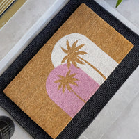 Sunset Palms natural coir doormat featuring soft pink and white arches with palm tree silhouettes