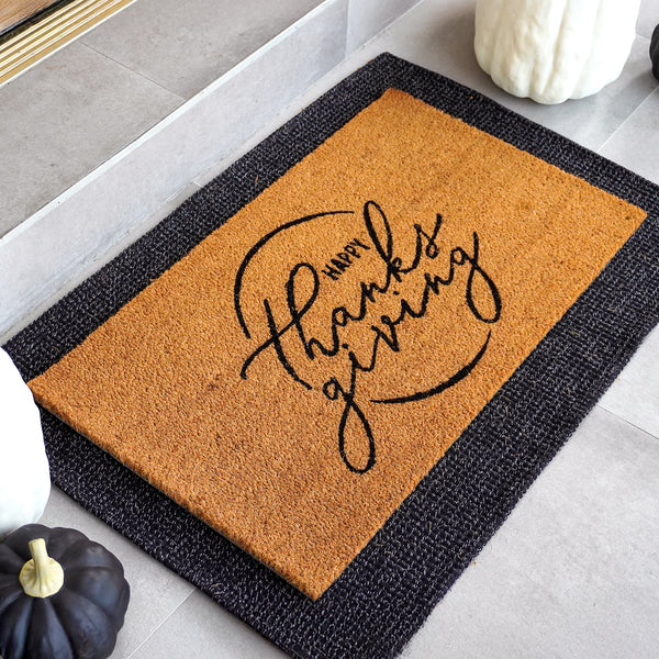 Happy Thanksgiving natural coir doormat with elegant script typography and circular flourish design