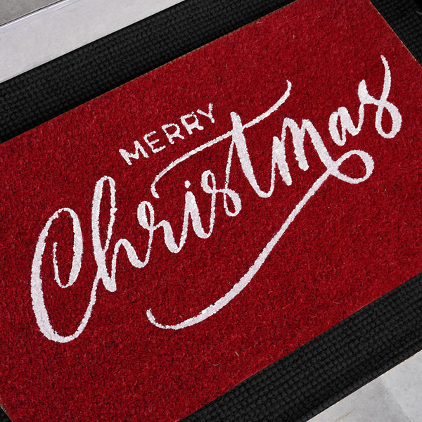 Red natural coir doormat with white Merry Christmas script lettering, shown