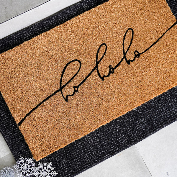 Festive Echo natural coir doormat featuring flowing 'ho ho ho' script in black on tan