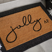 Jolly AF natural coir doormat with black script and bold lettering on tan coconut fiber background, shown